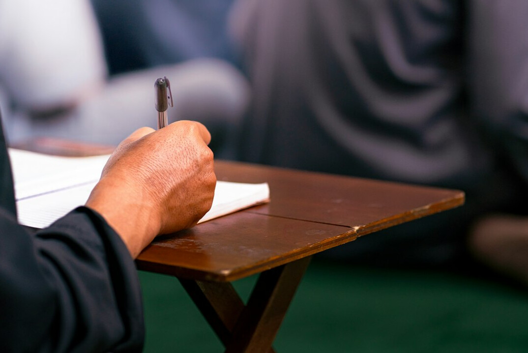 man taking notes during lecture