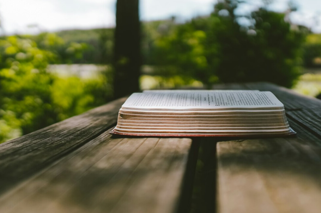 Open book lying on a wooden table